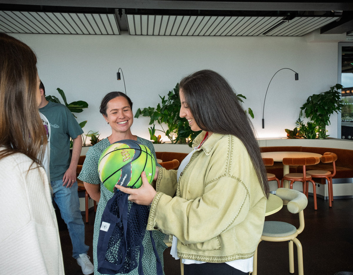 Emily Green being presented with a basketball complete with her winning design.